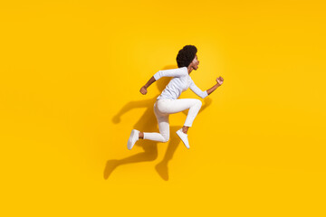 Fototapeta na wymiar Full body profile side photo of afro american brunette girl run jump empty space isolated on yellow color background
