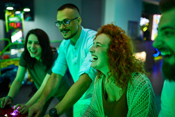 Happy friends playing and having fun in an amusement arcade