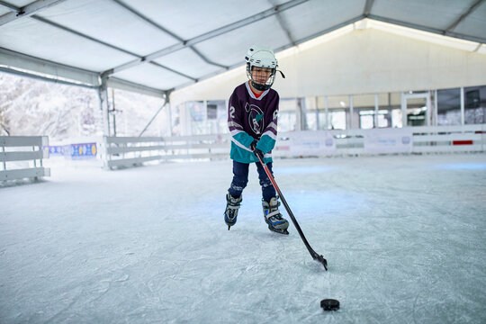 Boy playing ice hockey on the ice rink