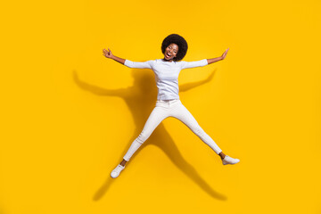 Fototapeta na wymiar Full length photo of dark skin happy woman jump up star shape smile isolated on yellow color background