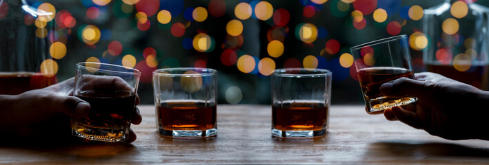 Cheers clinking of friends in party. Whisky In A Glass. Light Bokeh Background.
