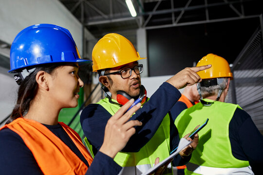 Man talking to female worker in factory workshop