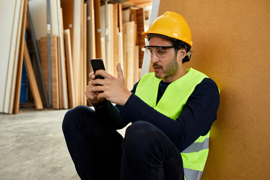 Worker using cell phone during a break in factory