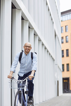 Happy man cycling bicycle on street in city