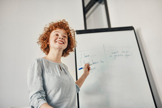 Smiling businesswoman leading a presentation at flip chart in conference room