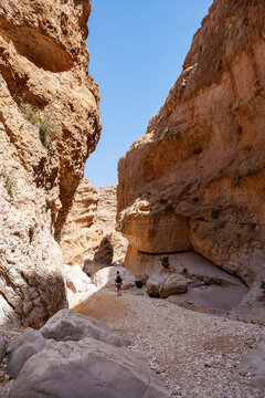 Man walking through rocks, Wadi Bani Khalid, Oman