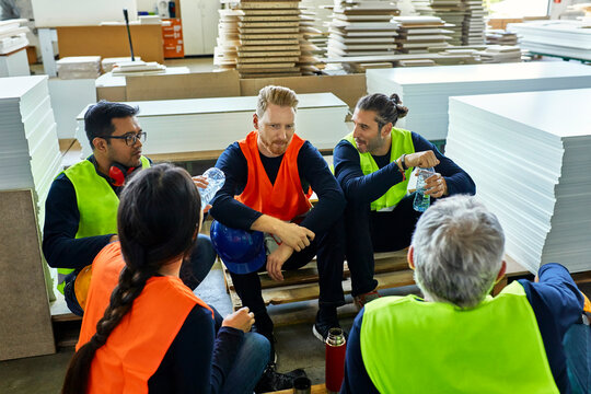 Workers in factory having lunch break together