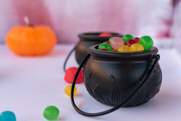 little cauldrons and halloween pumpkins crammed with treats on bloodstained white tablecloth