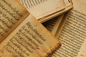 Stack of open ancient books in Arabic. Old Arabic manuscripts and texts. Top view