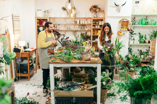 Man And Woman Working While Standing At Flower Shop