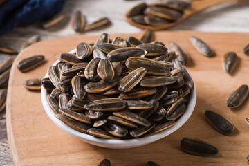 roasted sunflower seeds in small plate on wood background