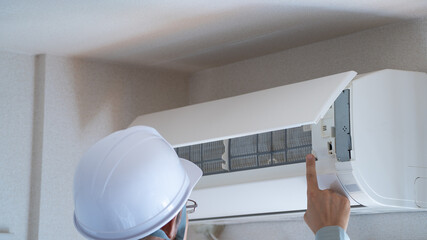 エアコンの点検をする作業員