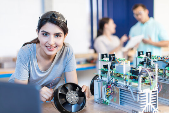 Portrait of smiling woman working on computer equipment
