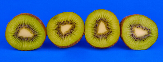 Fototapeta premium Sliced kiwi fruits on blue background