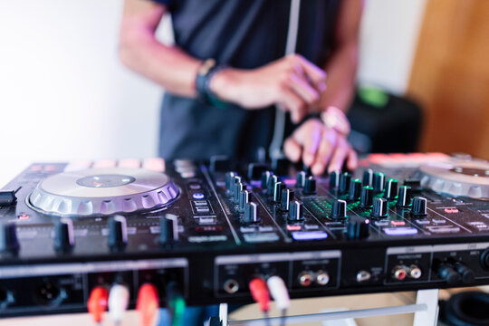 Young male music producer mixing sound at recording studio
