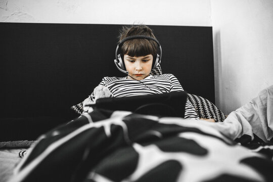 Bboy doing home work on tablet lying in bed