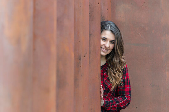 Portrait of smiling young woman wearing red plaid shirt