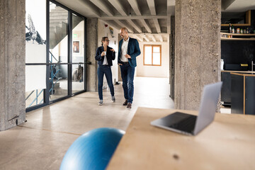 Business people discussing while walking at office