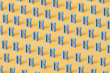 Blue pencil sharpeners against yellow background