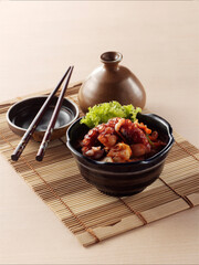 Octopus and cabbage spicy stir fried , Korean food on bamboo placemat on wooden background.