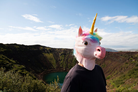 Man wearing unicorn mask standing at Kerid Crater, Selfoss, Iceland