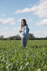 Vertical shot of a young Caucasian lady from Argentina posing in a sunny rural fie