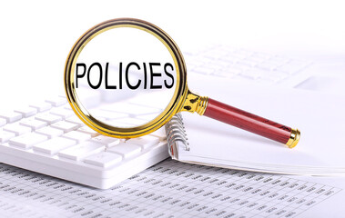 POLICIES word through magnifying glass on keyboard on the chart