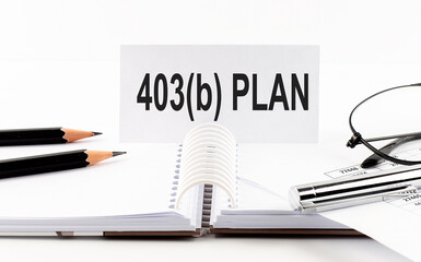 403b PLAN on paper card,pen, pencils, glasses,financial documentation on table - business concept