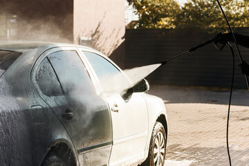 Car washing. Cleaning car using high pressure water.