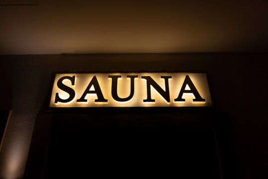 Illuminated sauna sign in dark at health spa