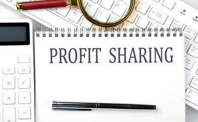 PROFIT SHARING Text on notepad with calculator and keyboard,business concept
