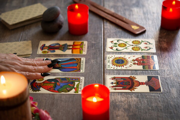 Fortune teller reading a future by tarot cards on rustic table	