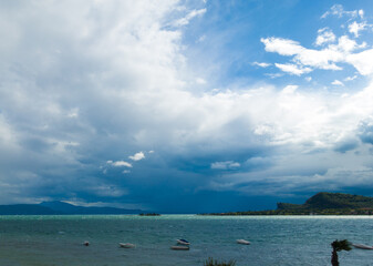 Ein Unwetter mit Gewitter zieht auf am Gardasee in der Bucht von Manerba del Garda mit dem Rocca 