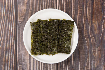 Crispy nori dried seaweed in plate on white background.  © zhikun sun