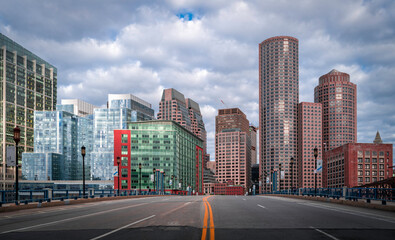 Boston downtown skyline and dramatic clouds over the Summer Street bridge road in Massachusetts