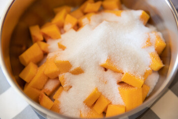 Sliced pumpkin and white sugar in a bowl for a fall recipe