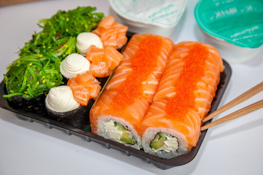Salmon sushi set. Sushi roll Philadelphia with red fish, salmon, red caviar. Roll with soft avocado and cream cheese under a layer of massago caviar. Classic sushi. Food background.