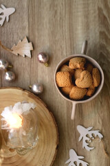Bowl of cinnamon cookies, lit candles and various Christmas decorations on the table. Flat lay.