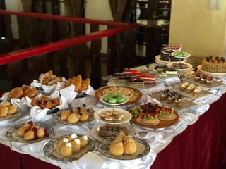 Serving a variety of desserts and sweet cakes of various kinds and types on the buffet table.