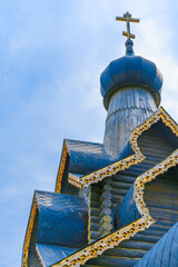 Wooden Russian Orthodox Church against the background of blue sky and clouds.