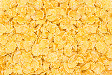 Light yellow corn flakes texture as a background. Top view cereal box for morning breakfast close up.