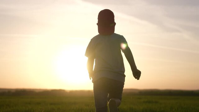 boy run. kid kid running a across the field in the park silhouette at sunset. happy family people in the park. boy run silhouette. happy childhood summer fun freedom concept. kid run