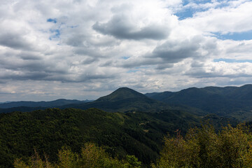 Fototapeta na wymiar Mountain and forest with dramatic cloudy sky