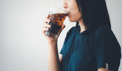 Woman drinking cola with ice.
