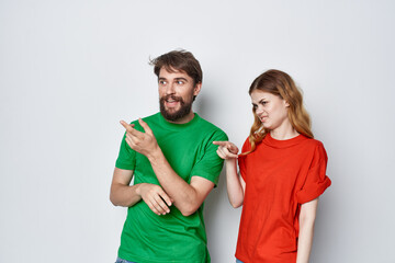 married couple multicolored t-shirts communication quarrel light background