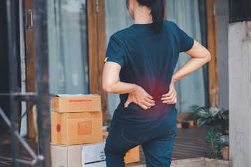 Woman with backache while lifting box.