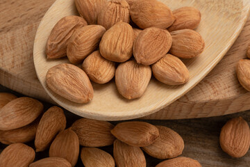 peach seed nuts, on a wooden background, close up