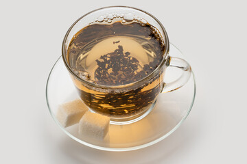 light ceylon leaf tea in a cup with sugar cubes, natural color.