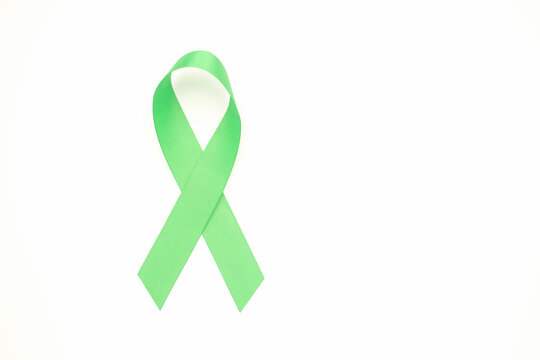 September world lymphoma awareness day and October world mental health day. Green ribbon isolated on a white background. Healthcare and medicine concept