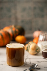 Pumpkin spice latte in a glass mug with cinnamon and creem